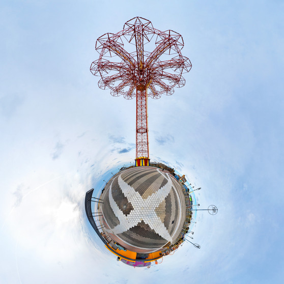 A 360-degree panoramic Spherescape featuring the iconic Parachute Jump in Coney Island, NYC, with its red structure central against a surrounding inverted landscape and blue sky.
