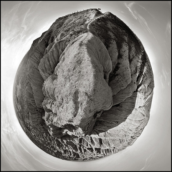 360-degree black and white panoramic view of the textured landscape of Badlands National Park, shaped like a terrestrial globe under a wide sky