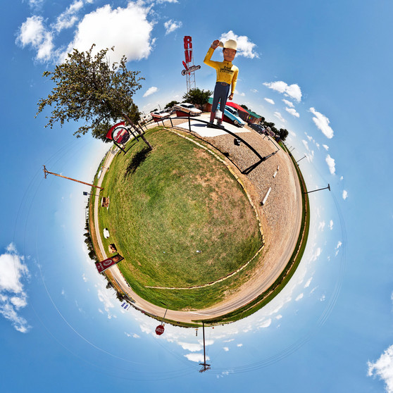 360-degree panoramic view of the "2nd Amendment Cowboy" sculpture at Cadillac Ranch near Amarillo, Texas, with surrounding landscape and clear skies.