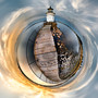 A 360-degree sunset panorama capturing Bug Light Lighthouse with golden sunset hues reflected in tranquil waters