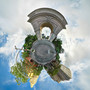 360-degree mid-afternoon panoramic image of the Washington Square Park arch in New York City, with surrounding greenery and buildings in a spherical composition.