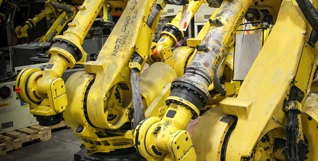 Row of damaged and dirty Fanuc robot units