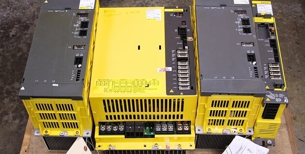 Three Fanuc spindle drives next to each other on work table