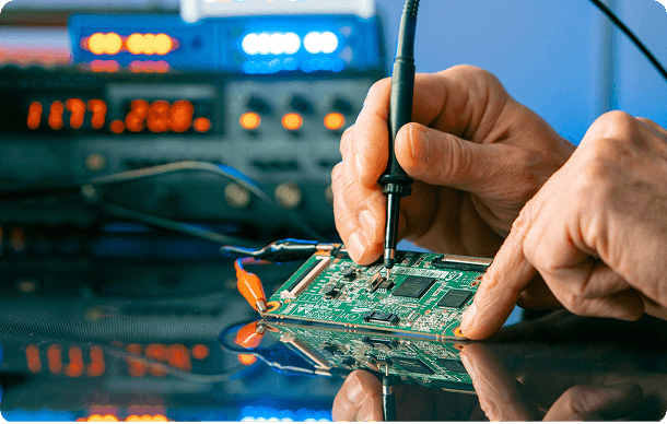 Engineer testing and soldering a circuit board for Fanuc spare parts repair
