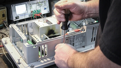 Close-up of TIE Industrial technician performing service on Fanuc parts
