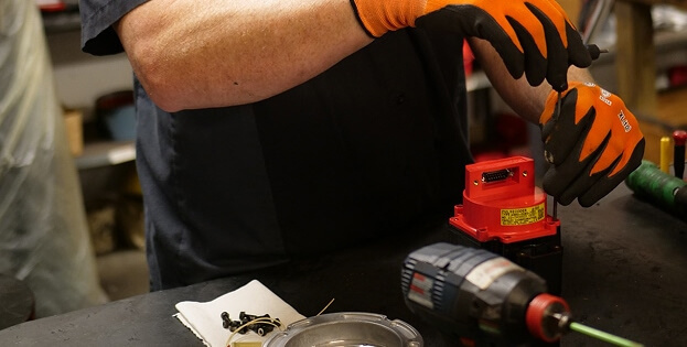 Close-up view of TIE Industrial technician working on Fanuc CNC parts
