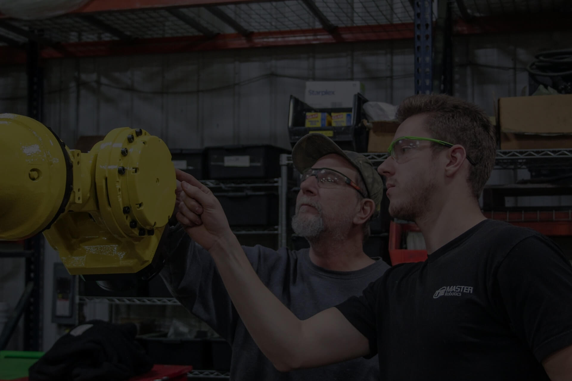 Two TIE Industrial employees repairing Fanuc robot wrist