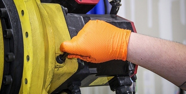 Close-up view of TIE Industrial technician performing preventative robot maintenance