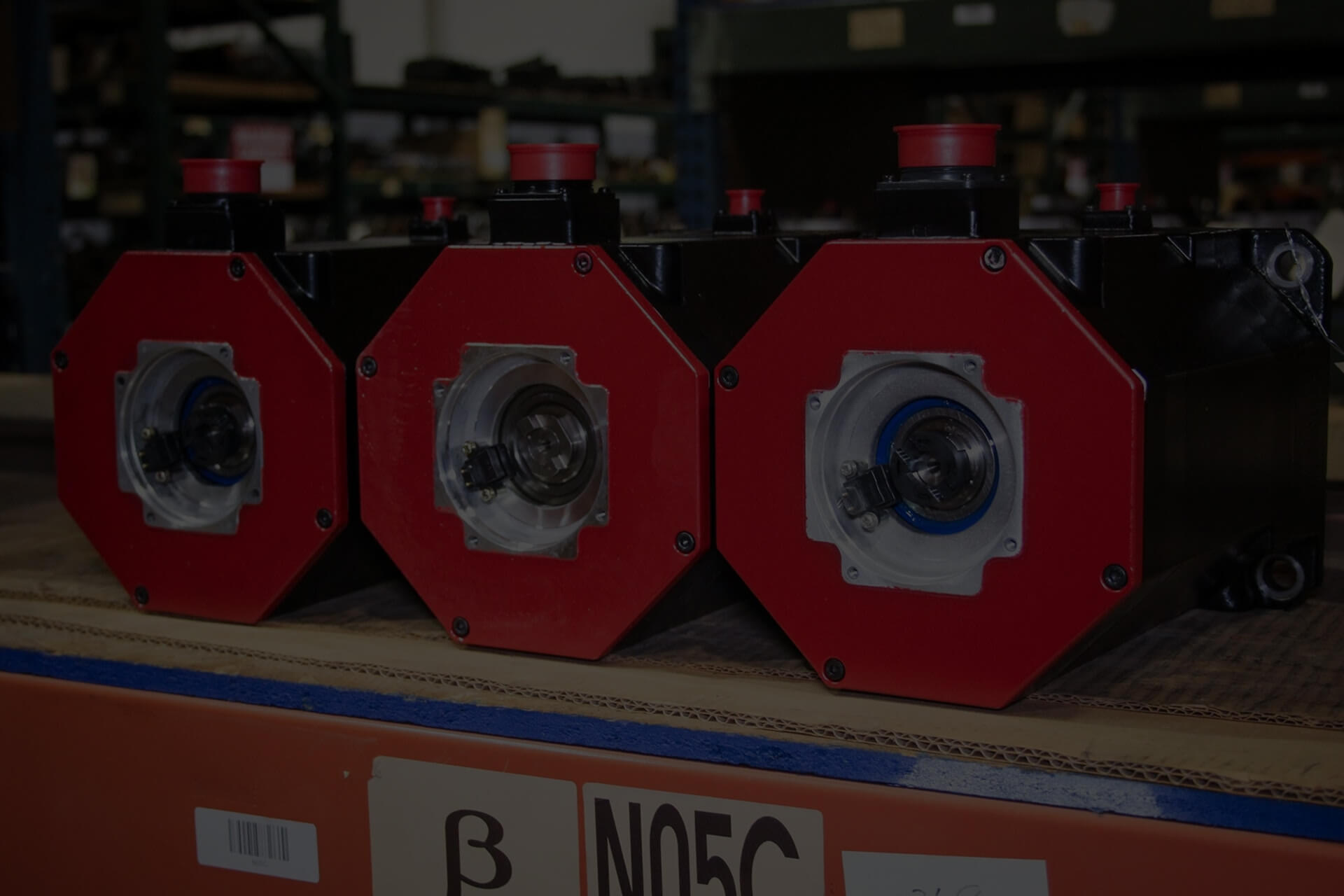 Three Fanuc spindle motors on shelf in warehouse