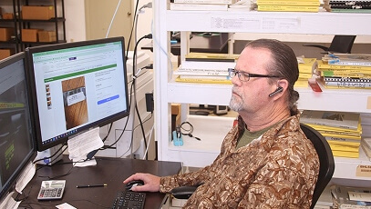 TIE Industrial technician sitting at desk looking at computer monitor