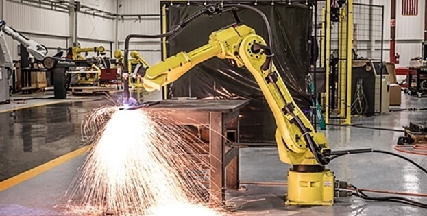 T.I.E. Industrial technician performing maintenance on a broken Fanuc robot