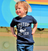 Youth Boston Whale T-shirt featuring a distressed "BOSTON EST. 1630" graphic with whale design, available in Light Pink and Navy colors, sizes XS through L.