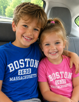 Hanes youth Boston 1630 Massachusetts t-shirt featuring a distressed collegiate-style graphic, available in Pink and Royal Blue colors, sizes XS through L.