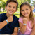 Minecraft Child Safety Bracelets-AA7700C, two kids showing off colorful safety bracelets with fun designs in a park setting.