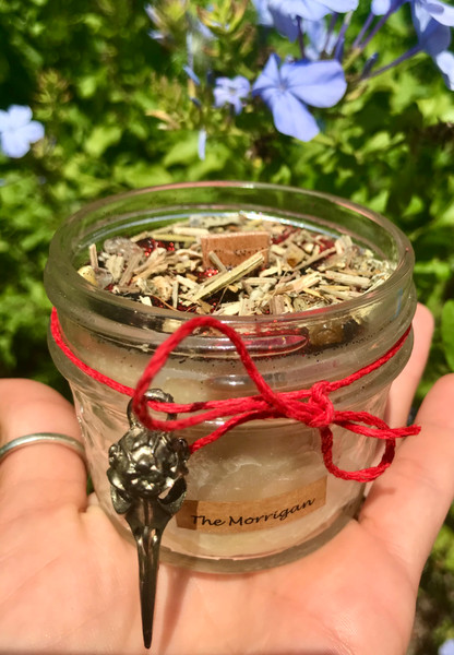 The Morrigan Wood Wick Candle- As always this is a pure beeswax candle hand poured from local beeswax. Scented with pure essential oils and finished with a wood wick.

The Morrigan has an earthy, herby scent. The Morrigan is a Goddess from the Celtic Pantheon. She is a Goddess of the Dead and a Warrior Goddess who is seen as a Guardian of the Dead. The essential oils in this candle are patchouli, rosemary, and mugwort. It is topped with vervain and rutilated quartz chip stones. Dreamer Apothecary
