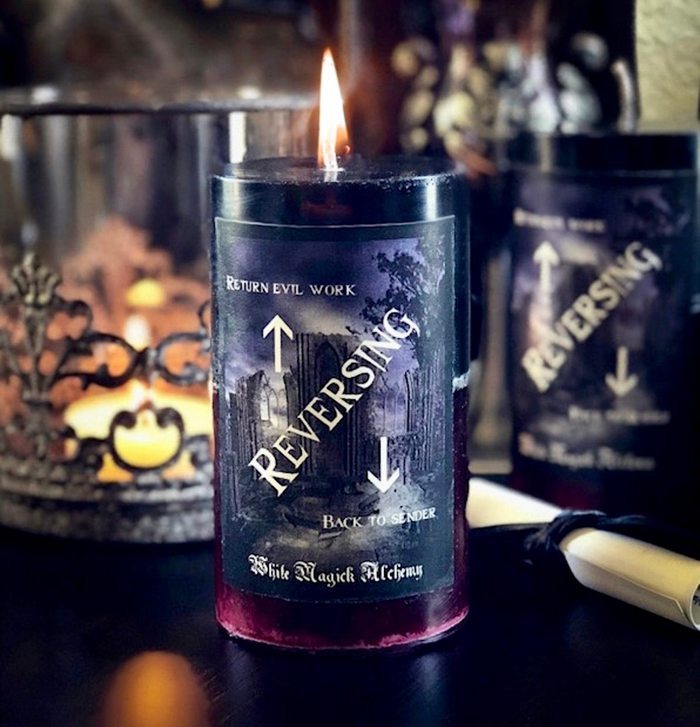 Red and black spell candle used in reversing rituals to return negative energy and break occult or voodoo-based influence, handcrafted for spiritual protection and cleansing work