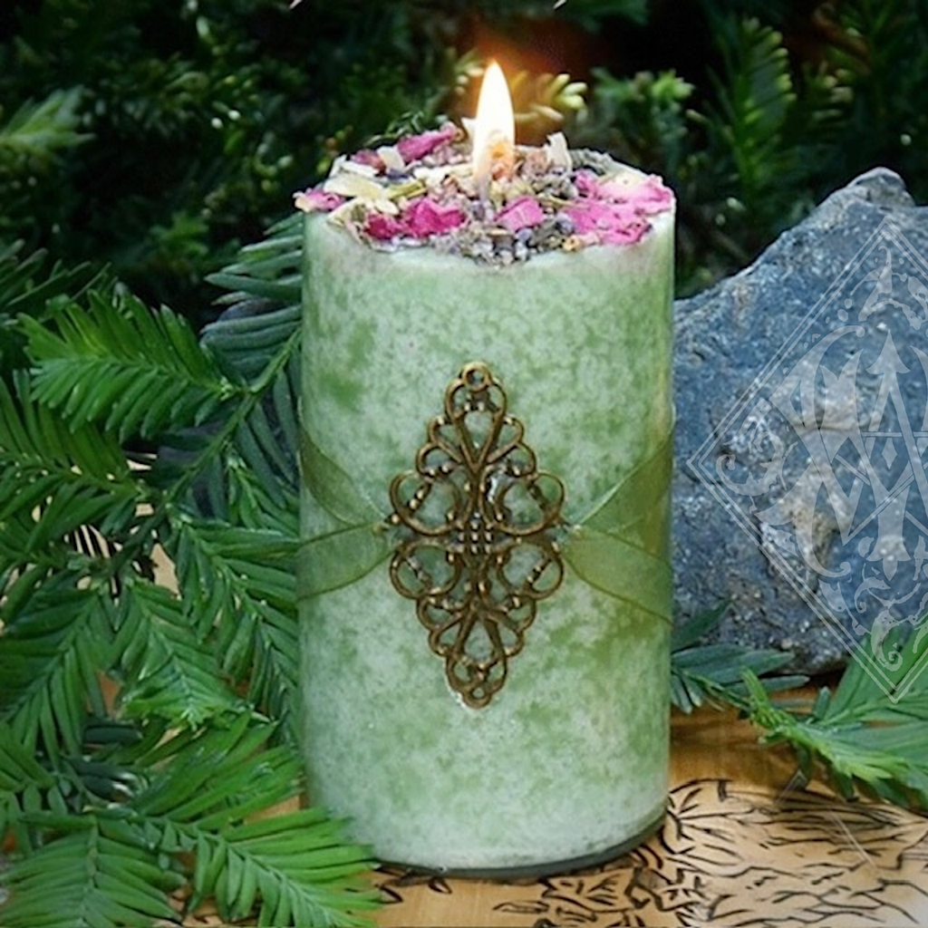 green goddess candle sitting in forest with rocks
