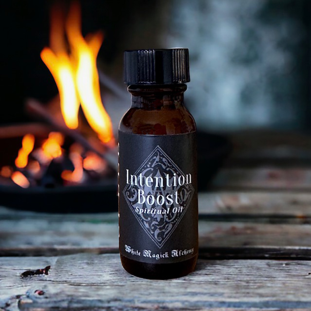 an amber bottle with fire and black label that reads intention boost by white magick alchemy