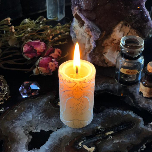 Close-up of jasmine Buddha candle showing embossed Buddha and lotus detail on petite antique meditation candle