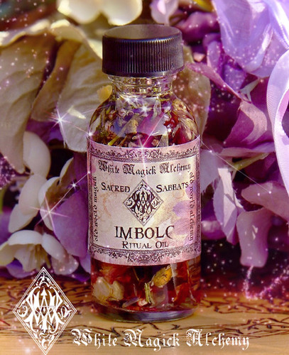 imbolc spell oils on wood table with winter flowers