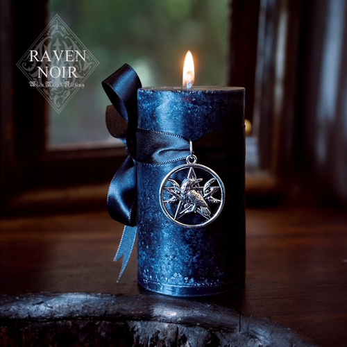 a black candle on a table with a raven pentacle triple moon pendant wrapped around it