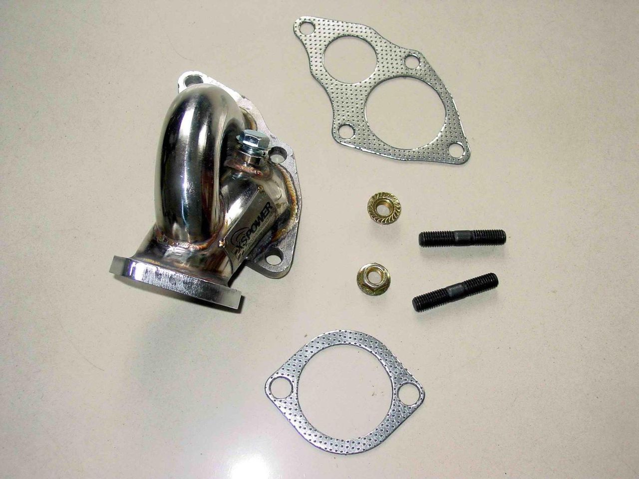 High-flow stainless steel turbo outlet dump pipe designed for DSM 4G63T applications using TD05 16G, 18G, and 20G turbochargers. Features mandrel-bent tubing, CNC-machined flanges, TIG and MIG welded construction, mirror-polished finish, and integrated O2 sensor bung. Direct bolt-on fitment for Mitsubishi Eclipse GST/GSX, Eagle Talon TSi, Plymouth Laser RS Turbo, and Galant VR-4 models.