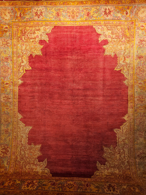 Late 19th Century Antique Turkish Oushak room size rug. Hand-woven. Open field pattern in brilliant red. Turquoise and yellow accents. Ivory, yellow, and red palmette and arabesque corner spandrels. Turquoise major border with designs in ivory, yellow, and red.
