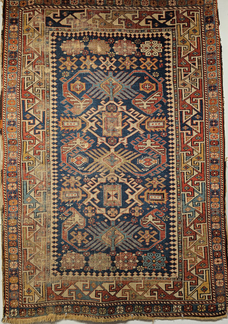 19th century Caucasian Shirvan area rug with navy blue field, ivory geometric border, and rust, green, and yellow accents, hand knotted with natural dyes, The Persian Knot Gallery, SKU: 2312