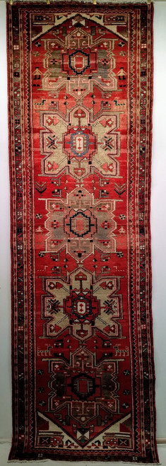 Vintage Persian Heriz runner with antique-red field, rare green medallions, and abrash gray-blue border. Handwoven in the mid-1900s. A collectible rug with rich color and character.