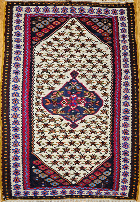 Mid-20th Century Vintage Persian Senneh (Bidjar) Kilim area rug with a central geometric medallion in dark blue, red, cream, yellow on an ivory field with small flower motifs. Ivory border with blue and red accent designs, The Persian Knot Gallery, SKU 14
