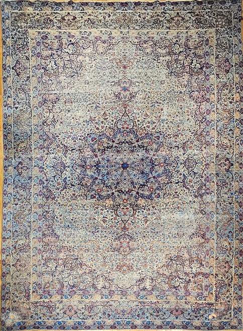 Late 19th Century Antique Oversize Persian Kerman Lavar rug. Hand-woven. Art Nouveau floral design similar to Louis Comfort Tiffany's Wisteria Lamp. Cream color field. Central medallion. Colors: turquoise blue, green, red, brown. Worn with repairs in corn