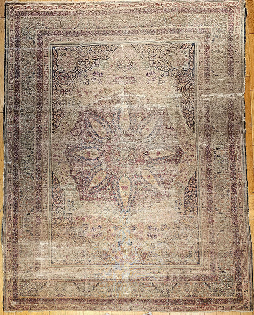 Late 19th Century Antique Persian Kerman Lavar area rug. Hand-woven. Distressed or "shabby chic" look. Floral pattern with central medallion. Primary colors: purple, yellow, blue, and pink. Over 150 years old.