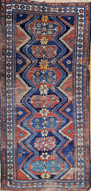 Early 20th Century Vintage Persian Kurdish tribal area rug or wide runner. Hand-knotted. Geometric pattern with seven small medallions in a single column. Main field in blue and rust colors. Multiple borders in beautiful colors and designs. Natural vegeta