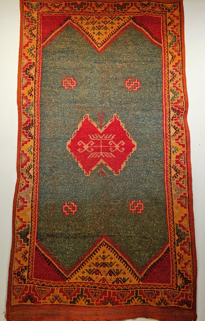 Vintage Moroccan area rug with geometric medallion in aqua green, saffron yellow border, and red-brown accents.