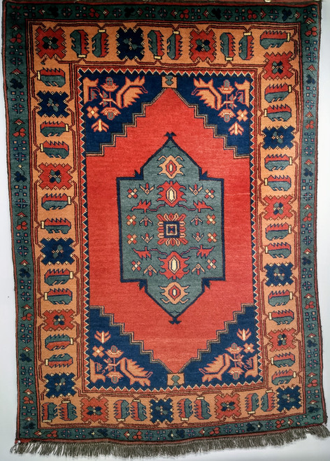 Vintage Kurdish tribal area rug. Hand-woven. Central green medallion on a rich red field. Saffron-colored border with designs in red, green, and blue. Final outer border in green. Small size.