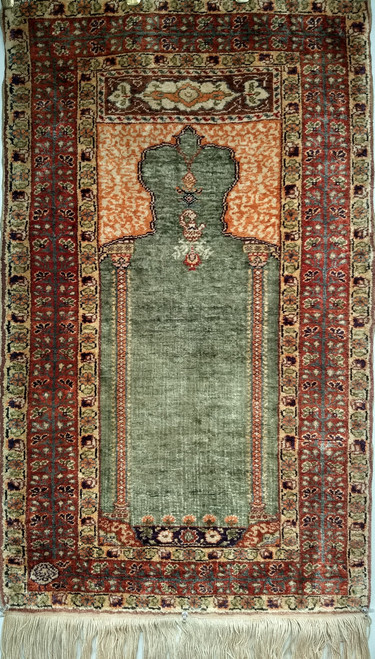 Turkish Hereke silk prayer rug in rare green, orange, red, and plum tones with fine knotting and a sewn sleeve for wall display, The Persian Knot Gallery, SKU: 1392