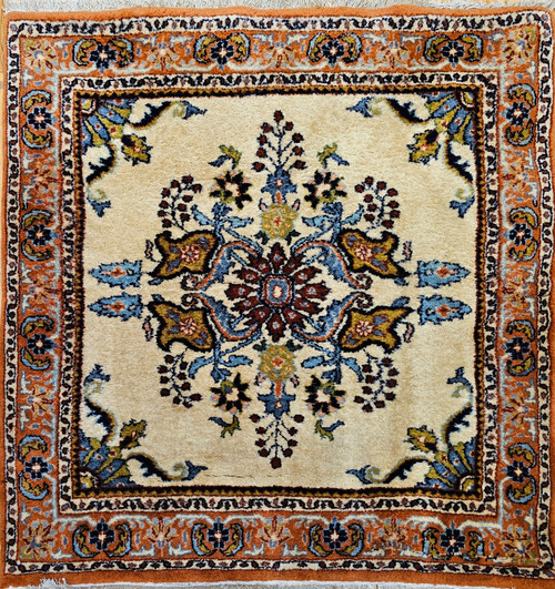 Vintage square Persian Bakhtiari rug with central floral medallion on ivory background in red, blue, green, and brown tones