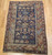 19th century Caucasian Shirvan area rug with navy blue field, ivory geometric border, and rust, green, and yellow accents, hand knotted with natural dyes, The Persian Knot Gallery, SKU: 2312