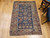19th century Caucasian Shirvan area rug with navy blue field, ivory geometric border, and rust, green, and yellow accents, hand knotted with natural dyes, The Persian Knot Gallery, SKU: 2312