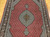 Vintage Persian Tabriz Mahi rug. Hand-knotted. Fine wool pile with silk accents. Geometric diamond pattern in alternating red and ivory. Richly detailed field. Burgundy border with shades of lavender, blue, and brown.