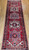 Vintage Persian Heriz runner with antique-red field, rare green medallions, and abrash gray-blue border. Handwoven in the mid-1900s. A collectible rug with rich color and character.