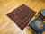 Mid-20th Century Vintage Afghan Baluch tribal area rug. Hand-knotted. Near square size. Geometric design in red and brown. Soumak kilim weaving incorporated in design.