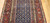 Late 19th Century Antique Kurdish gallery-size rug. Hand-woven. Paisley pattern. Blue background. Predominantly rust-colored border. Ideal for a hallway or as a wide runner.