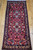 Early 20th Century Vintage Persian Bakhtiari tribal area rug or runner. Hand-knotted. All-over large format floral design on crimson background. Colors include ivory, green, yellow, blue, brown, and others. Beautiful and colorful design.