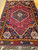 Mid-20th Century Vintage Persian Qashqai tribal area rug. Traditional design with one central dark blue medallion and four small ivory corner medallions on a red field. Features blue, green, and orange accents. All-wool, mostly vegetable dyes. Hand-knotte