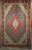 Early 20th century Persian Tabriz Mahi rug with geometric diamond medallions in cream, red, blue, and green. A fine hand-knotted collectible for luxury interiors.
