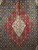 Early 20th century Persian Tabriz Mahi rug with geometric diamond medallions in cream, red, blue, and green. A fine hand-knotted collectible for luxury interiors.