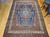 Late 19th Century Antique Persian Kurdish room size rug. Hand-woven. Oversized elongated diamond medallion pattern. Abrash blue color field with streaks of light blue. Medallions in rust, blue, and cream with vines and flowers. Cream-colored main border with geometric design. Colors: navy, French blue, green, yellow, red.