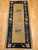 Late 19th century Chinese Peking rug with tan field, two floral bouquets, and navy border with leaf patterns.