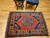 Vintage Kurdish tribal area rug. Hand-woven. Central green medallion on a rich red field. Saffron-colored border with designs in red, green, and blue. Final outer border in green. Small size.